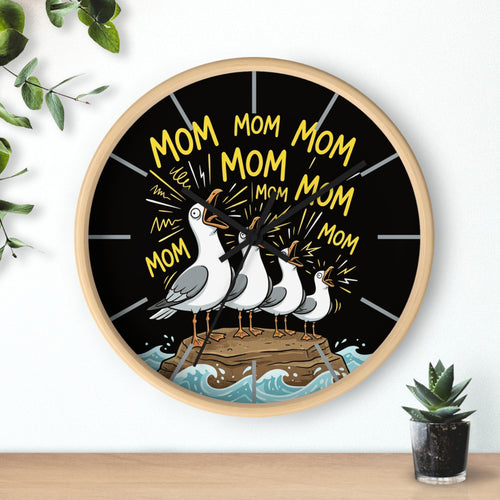 Wall clock with seagulls and 'Mom' text on a black background, placed on a white surface with a plant.