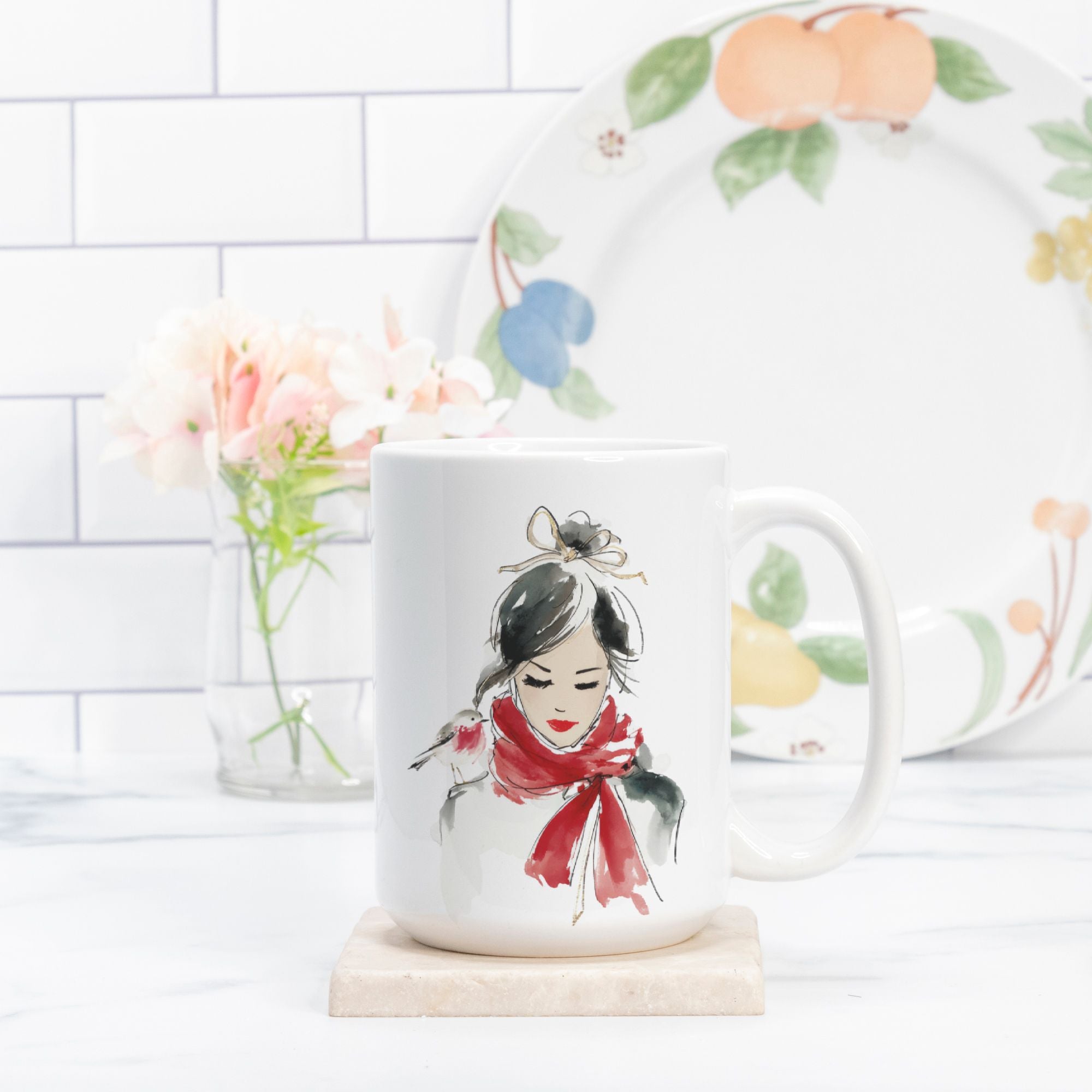 Mug with a design of a woman wearing a red scarf, placed on a white surface with a blurred background.