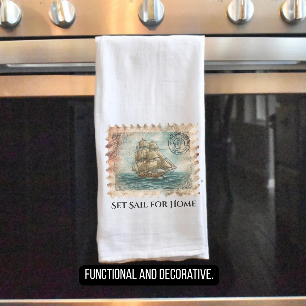 Towel with a ship stamp design hanging on an oven handle, labeled 'Set Sail for Home'.