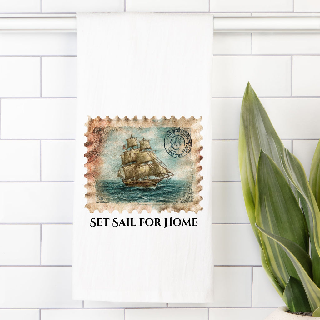 Decorative tea towel with a vintage ship design and 'Set Sail for Home' text on a white tiled wall.