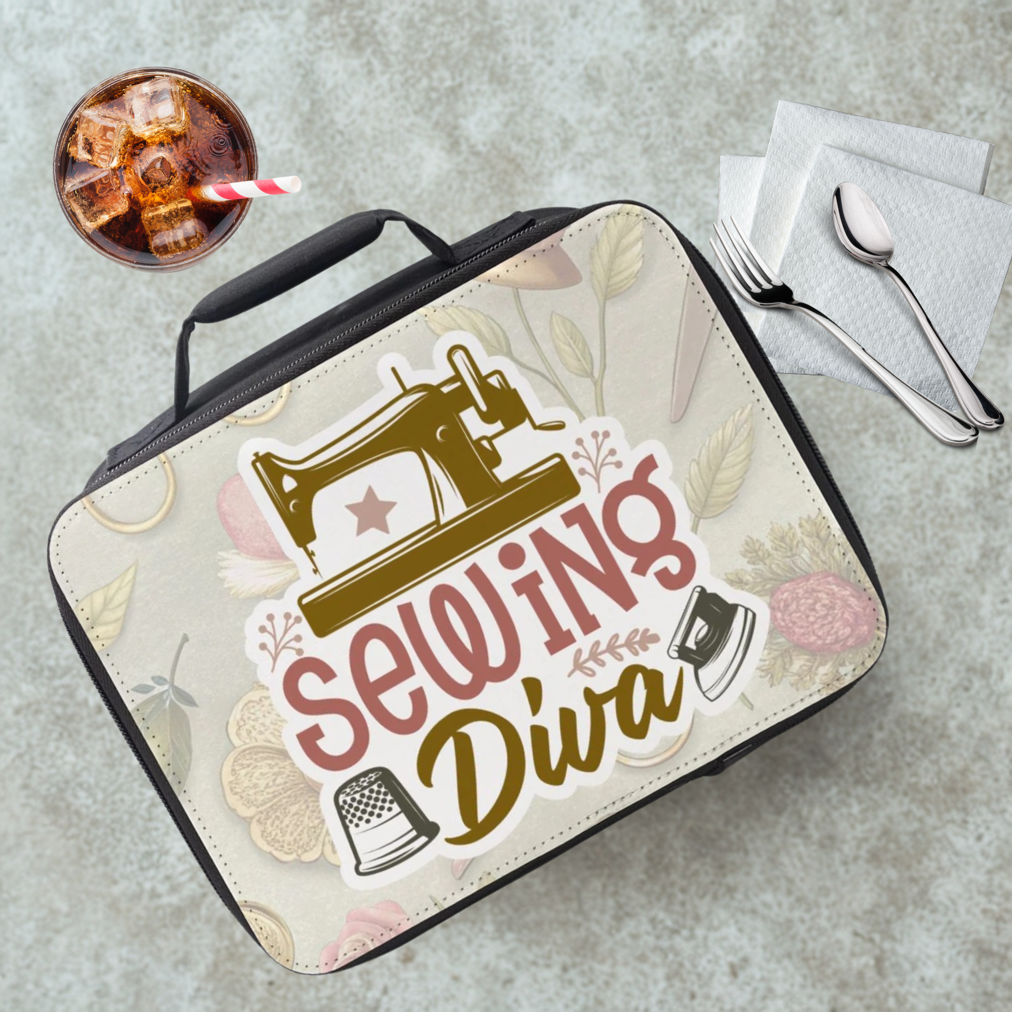 Lunch bag with 'Sewing Diva' design on a cafeteria table with a drink and utensils.