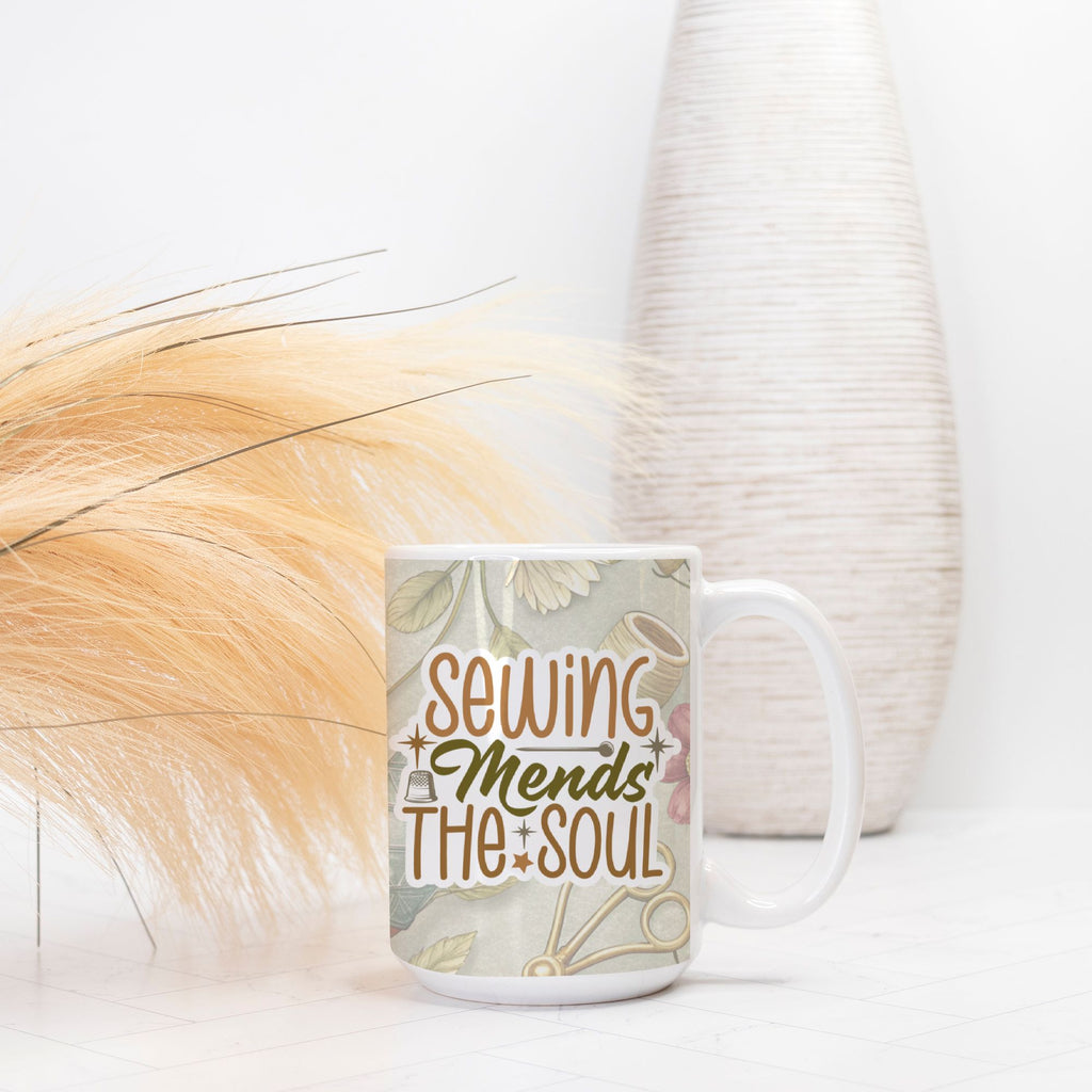 Mug with 'Sewing Mends The Soul' text on a floral background, placed on a surface with decorative elements.