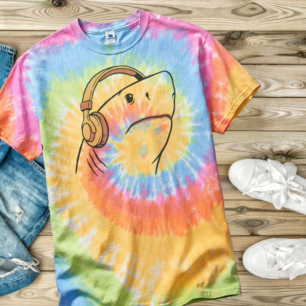 Tie-dye t-shirt in the color Eternity with a hand drawn shark wearing headphones on a wooden surface.