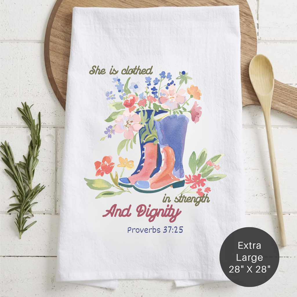 Decorative tea towel with floral design and text on a wooden surface