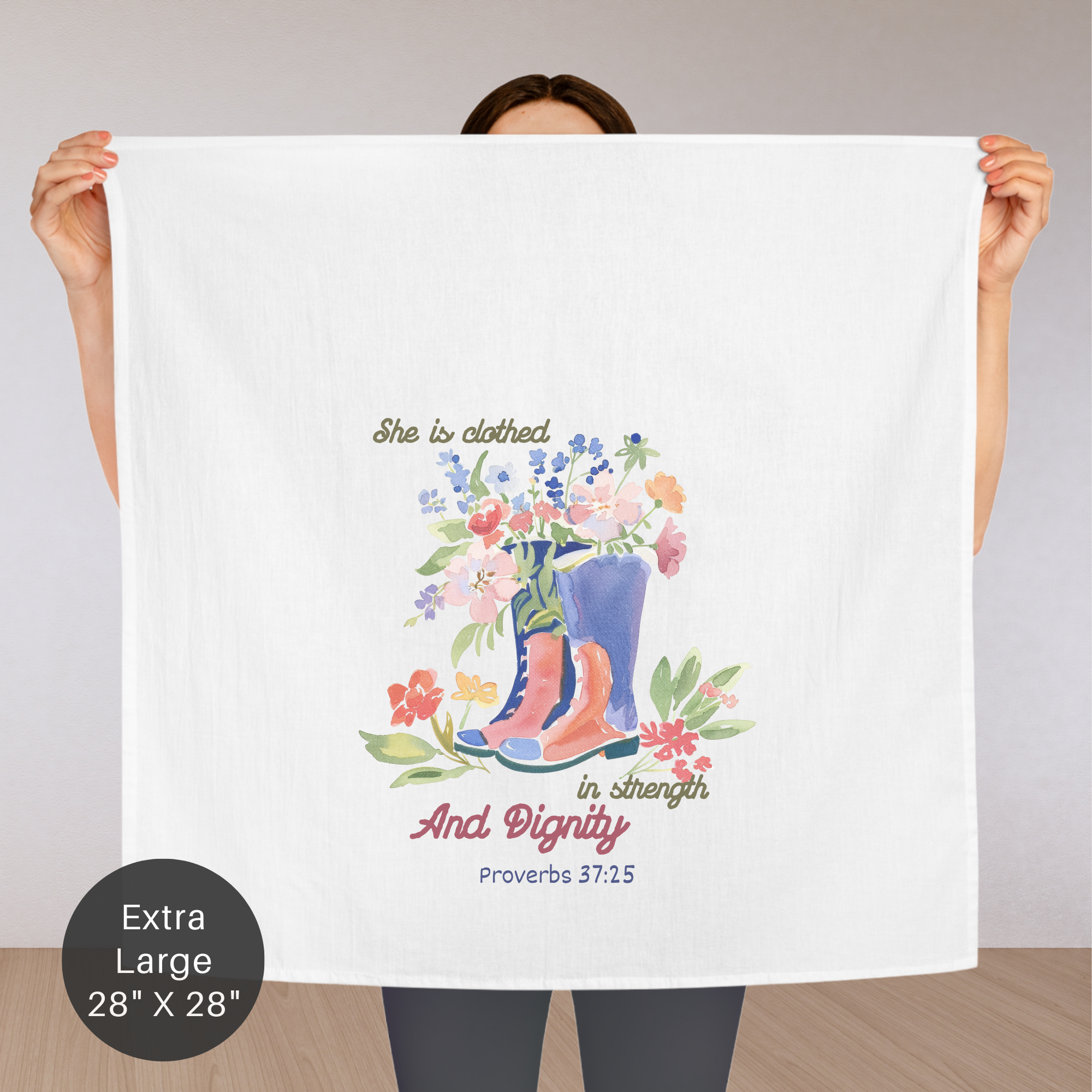 Person holding an extra large towel with floral design and text on a plain background