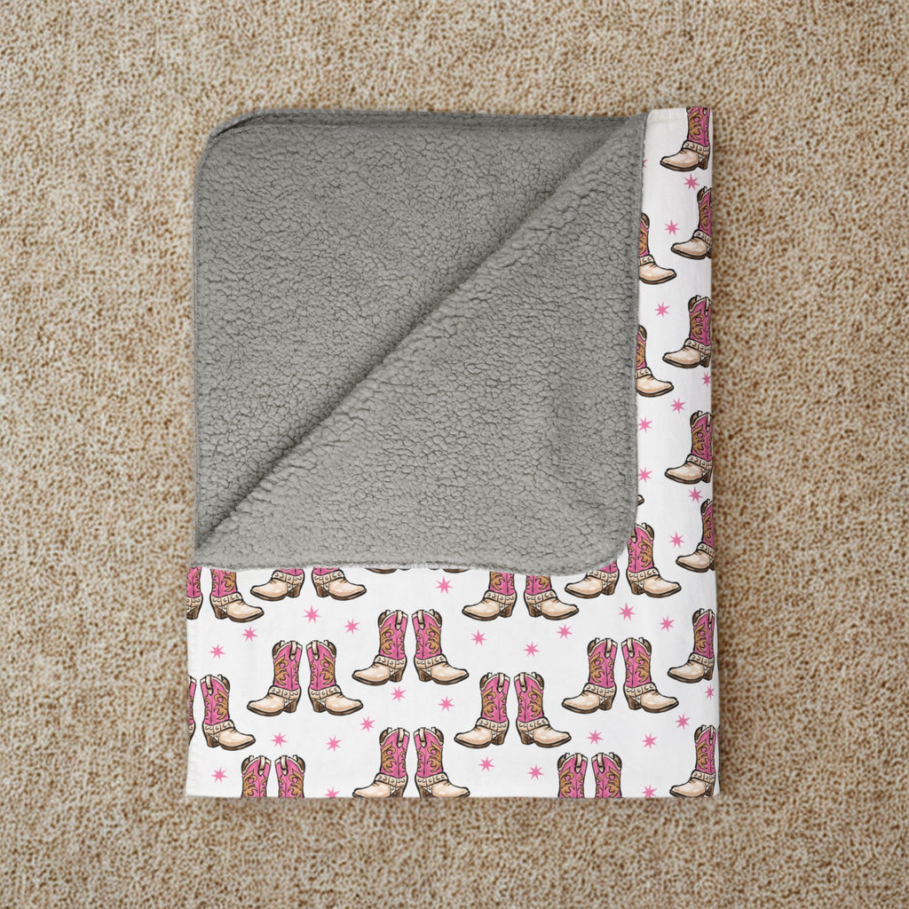 Gray hooded towel with cowboy boot pattern on a beige carpet