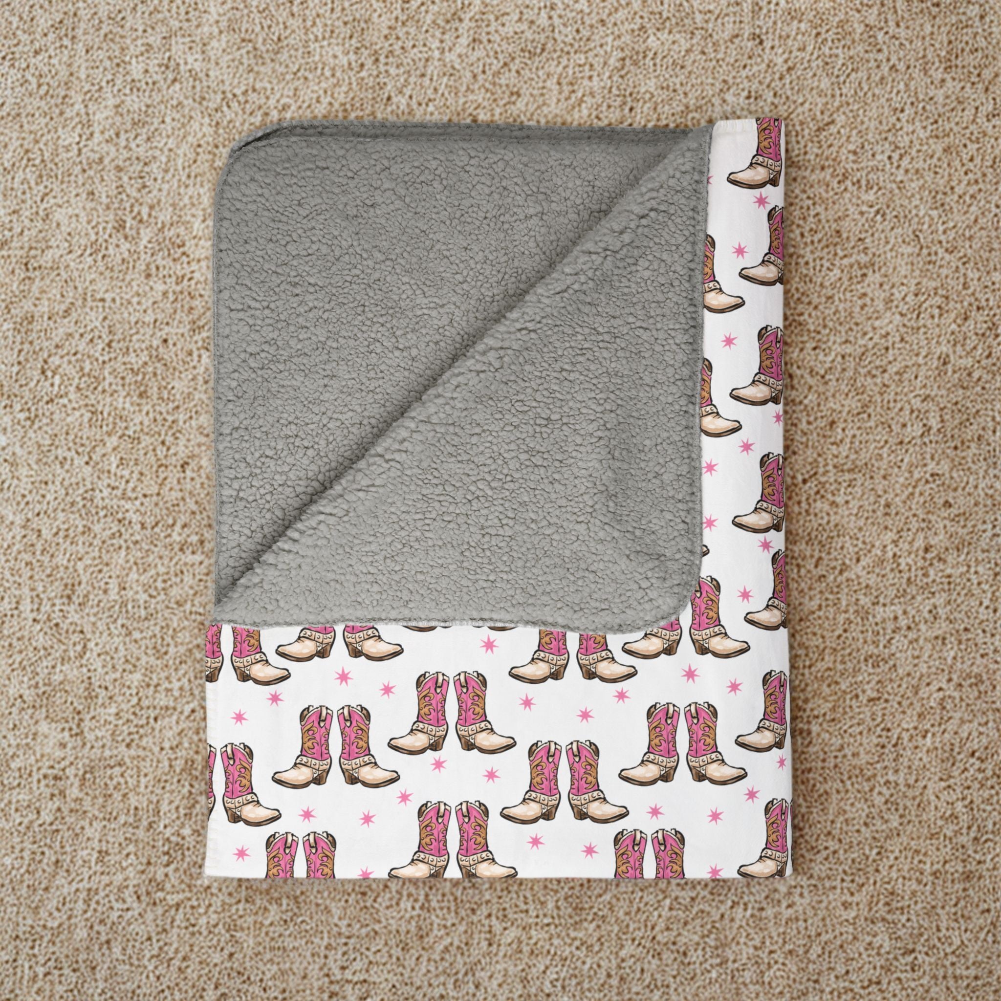 Gray hooded towel with cowboy boot pattern on a beige carpet