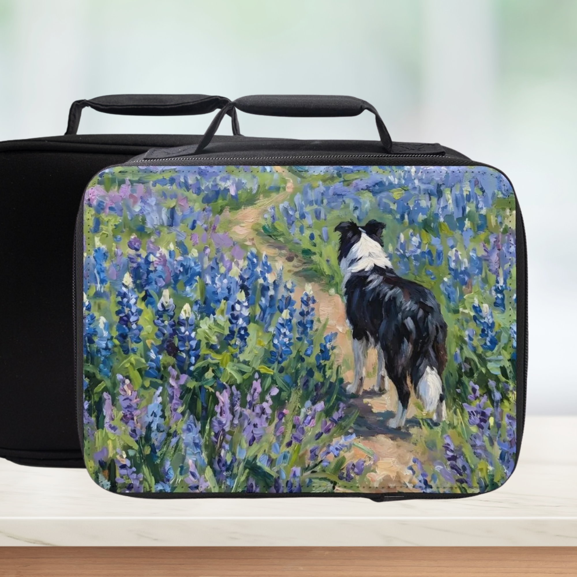 Black lunch bag with a design of a Shetland sheep dog walking through flowers on a white surface.