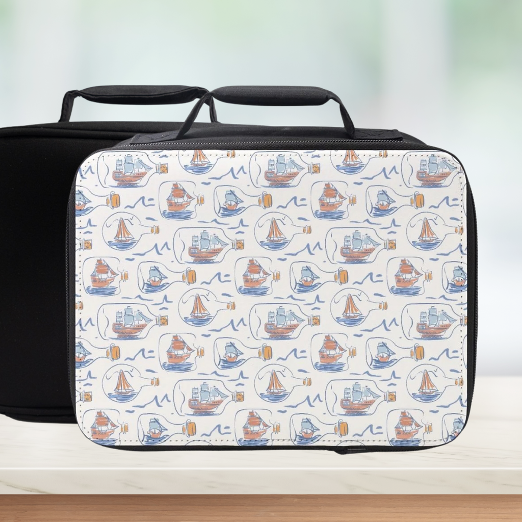 Black lunch bag with a white pattern of hand drawn ships in bottles on a light background