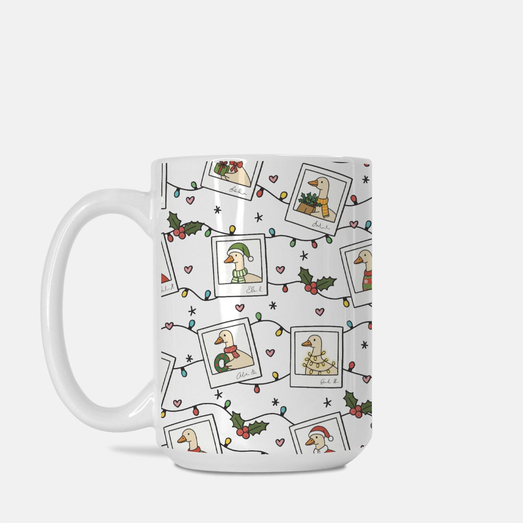 White mug with festive design featuring illustrations of a duck, holly leaves, and Christmas lights on a white background.