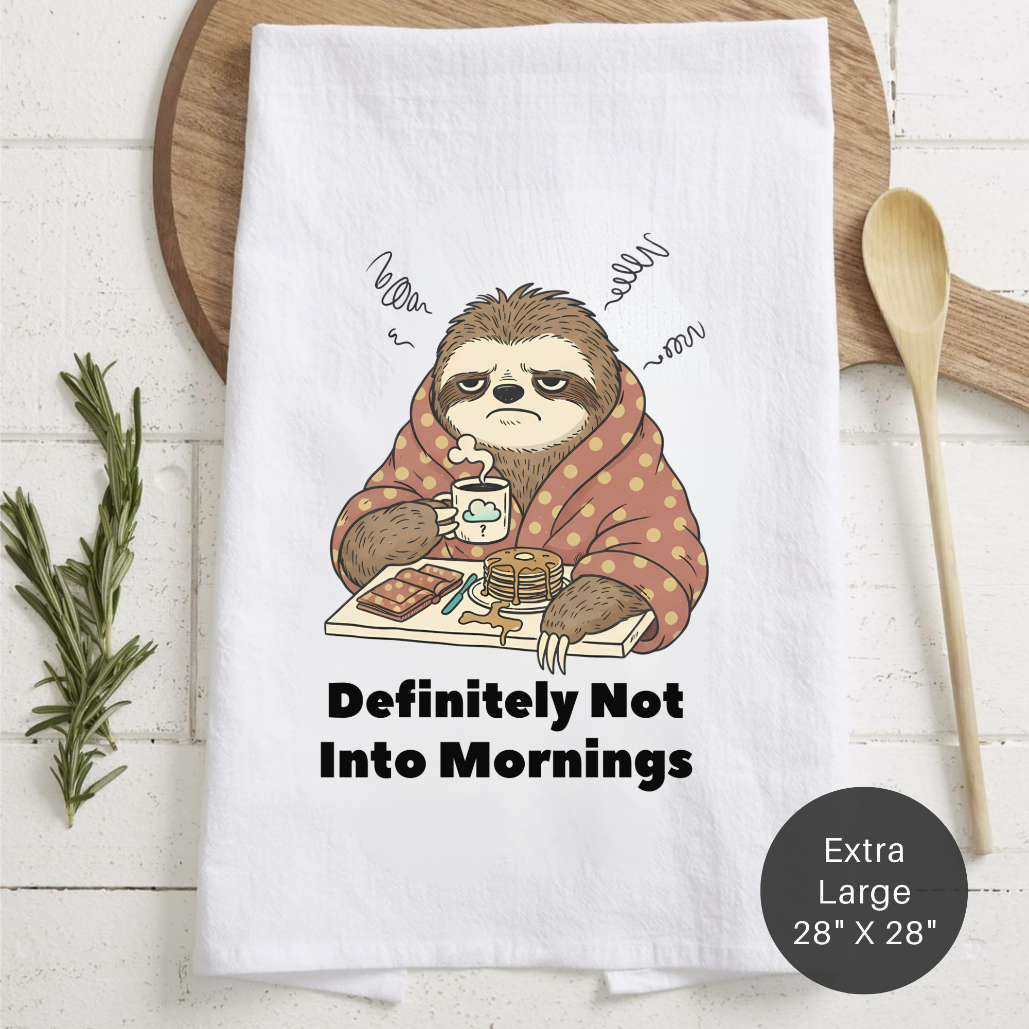 Tea towel with sloth design and text 'Definitely Not Into Mornings' on a wooden surface.