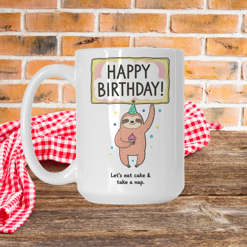 White mug with a sloth design and birthday text on a wooden surface with a brick background