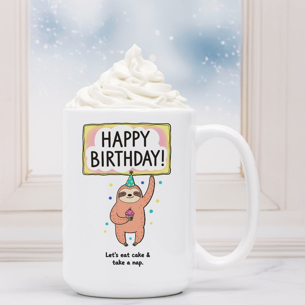 White mug with a sloth holding a birthday sign and text, against a snowy window background.