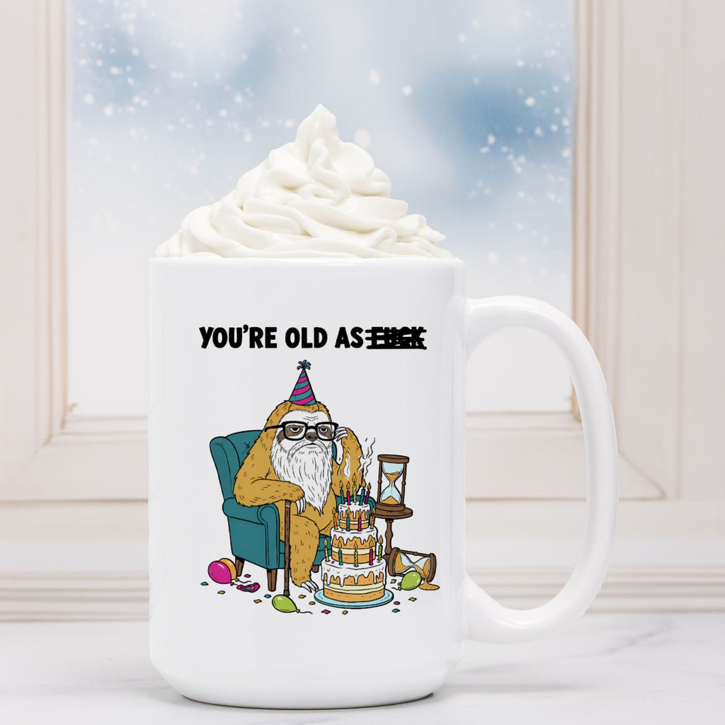 White mug with a cartoon design of a bear celebrating a birthday, text 'You're old as F***'.