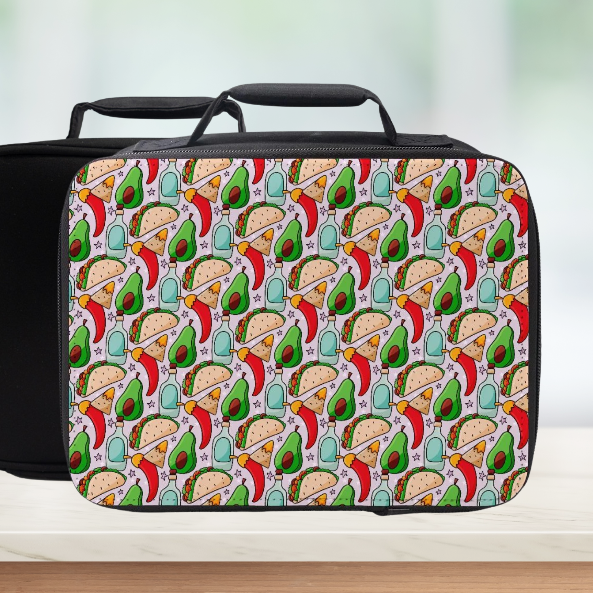 Lunch bag with a colorful pattern of avocados, tacos, and bottles on a light background