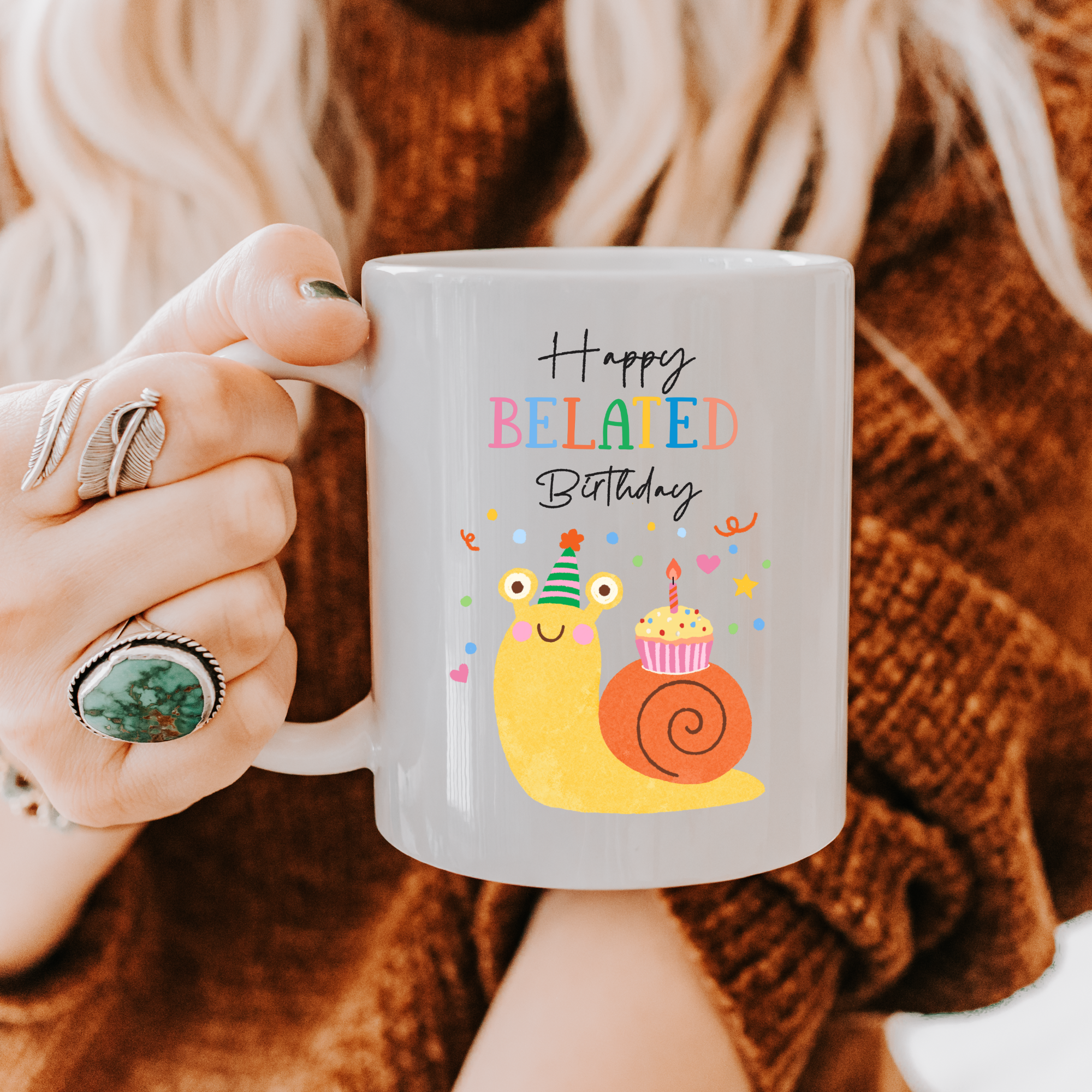 Person holding a 11oz. mug with a snail and birthday cake design and 'Happy Belated Birthday' text.