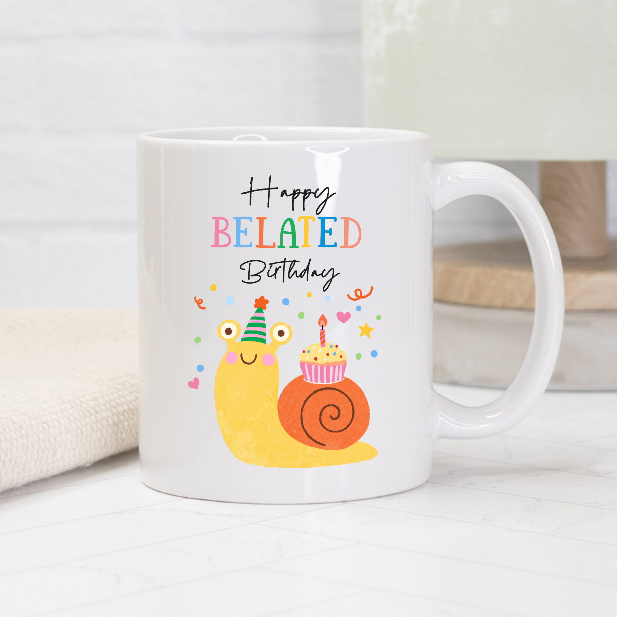 White 11oz. mug with a cartoon snail, birthday hat, and cupcake on a white surface.