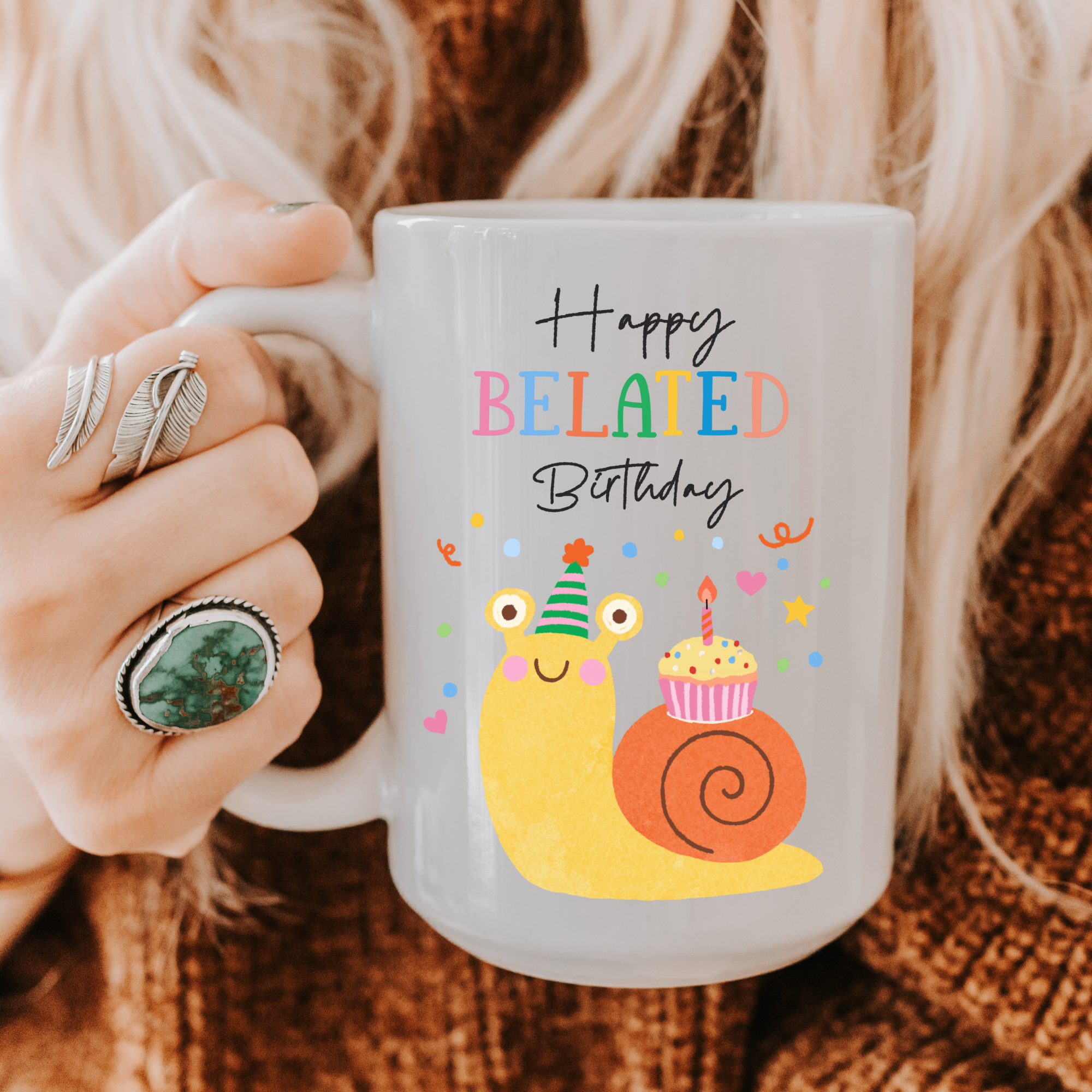 Person holding a 5oz. mug with a snail and birthday cake design and 'Happy Belated Birthday' text.