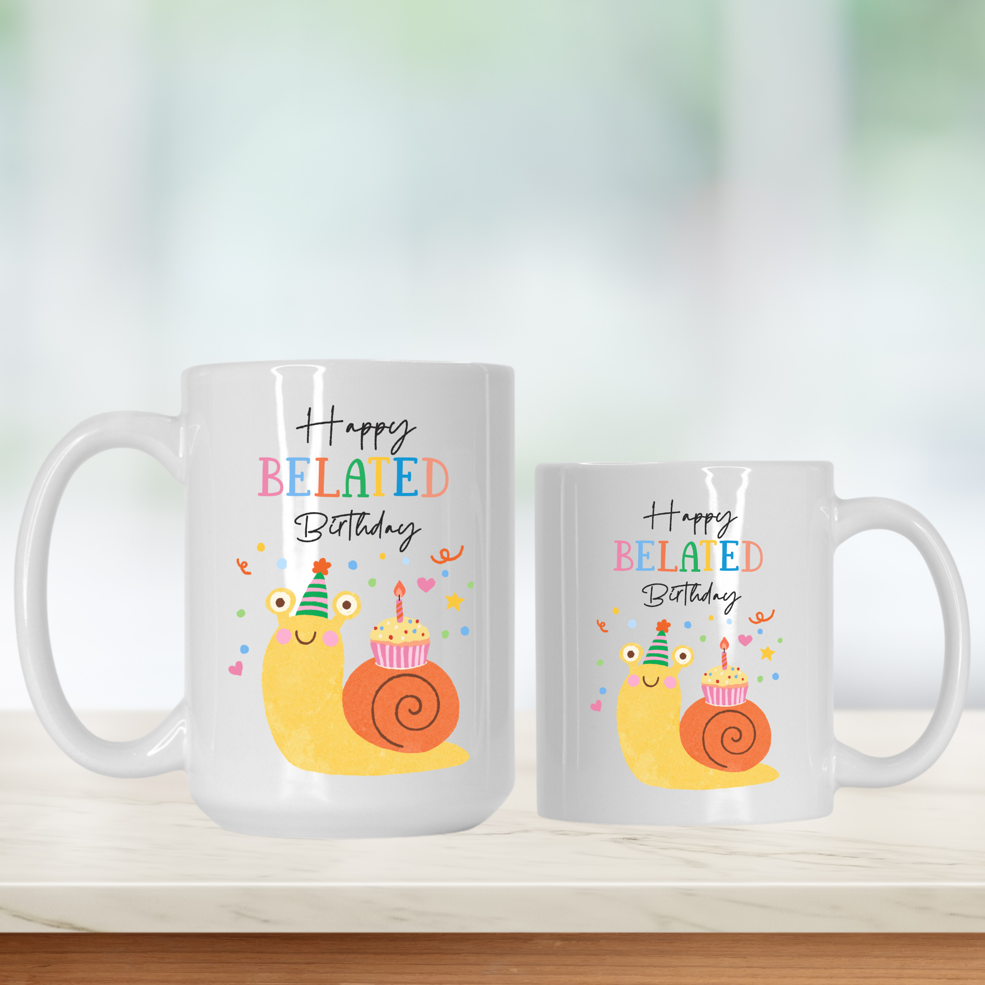 15oz. & 11oz. mugs with snail illustrations and 'Happy Belated Birthday' text on a white background