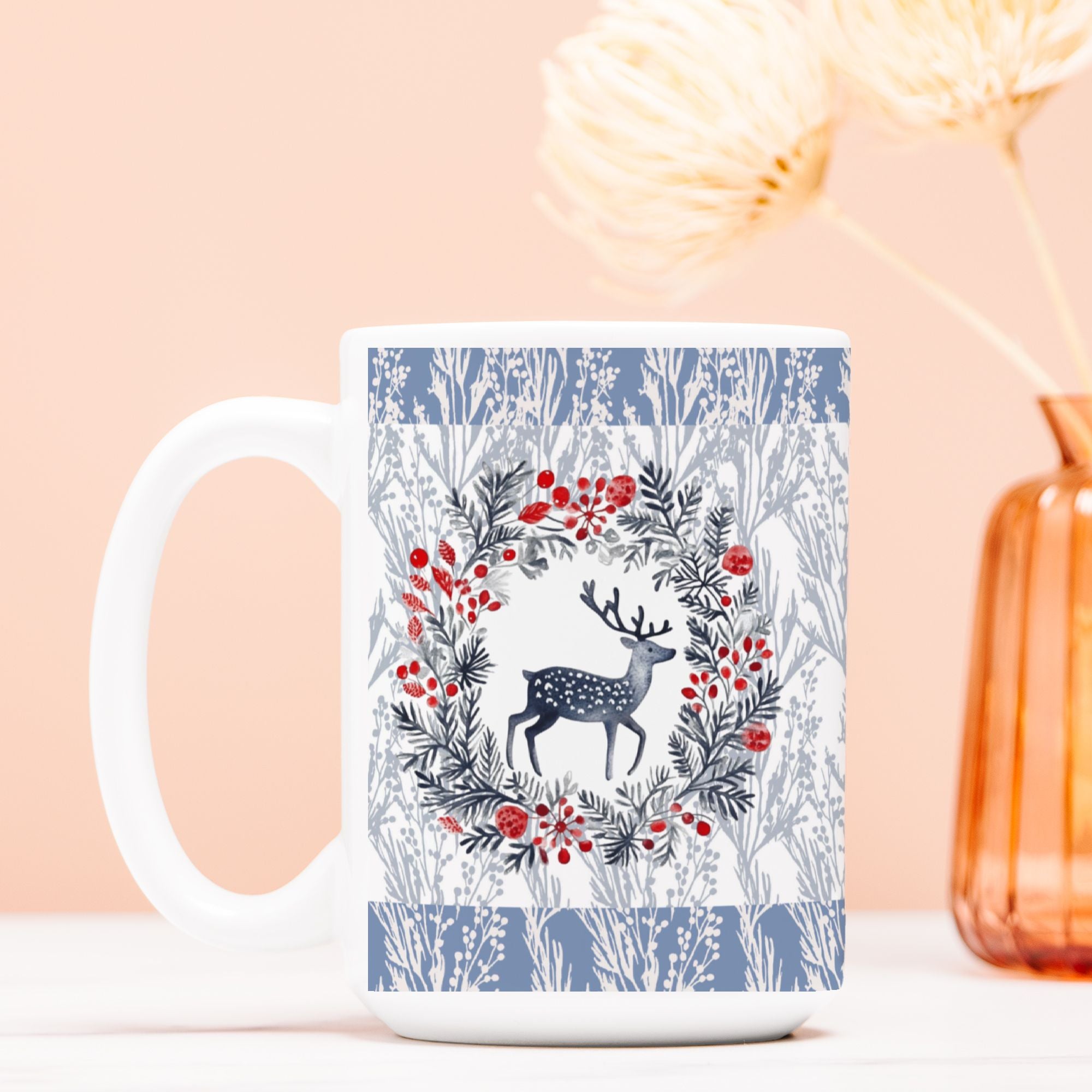 White mug with a deer and floral Christmas wreath design on a light pink background