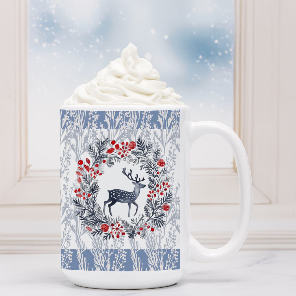 White mug with a deer and floral design, filled with hot chocolate and whipped cream, against a snowy background.