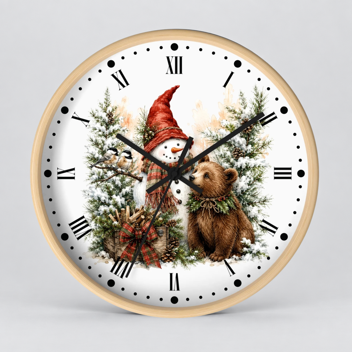 A round wall clock with a light wood frame and a white face featuring a winter holiday illustration of a snowman in a red hat, evergreen trees, a bear, and a gift box. The clock is shown against a neutral light gray background.