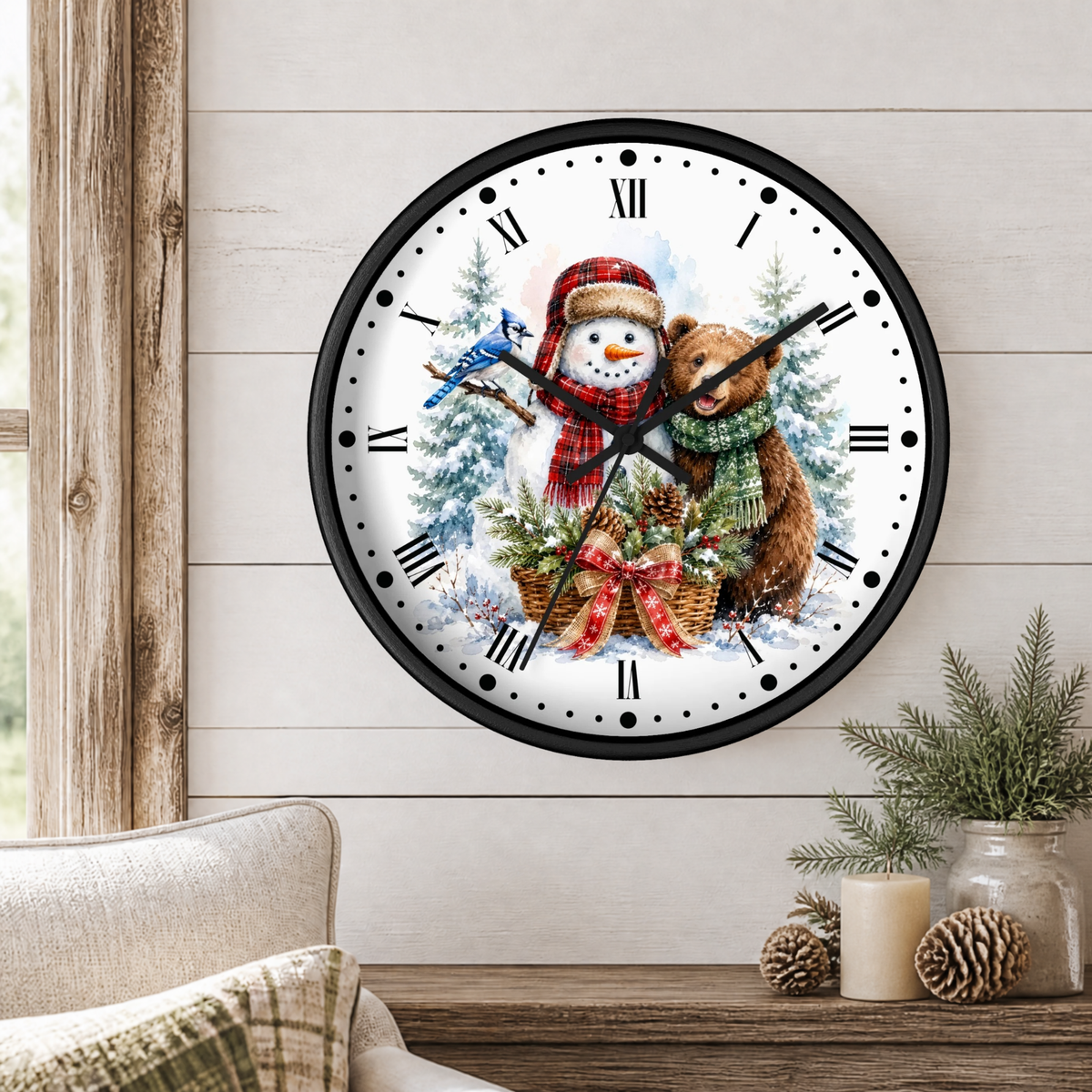A round wall clock with a black frame and a festive winter illustration of a snowman and a bear, displayed on a light wood paneled wall above a wooden table with holiday decor.