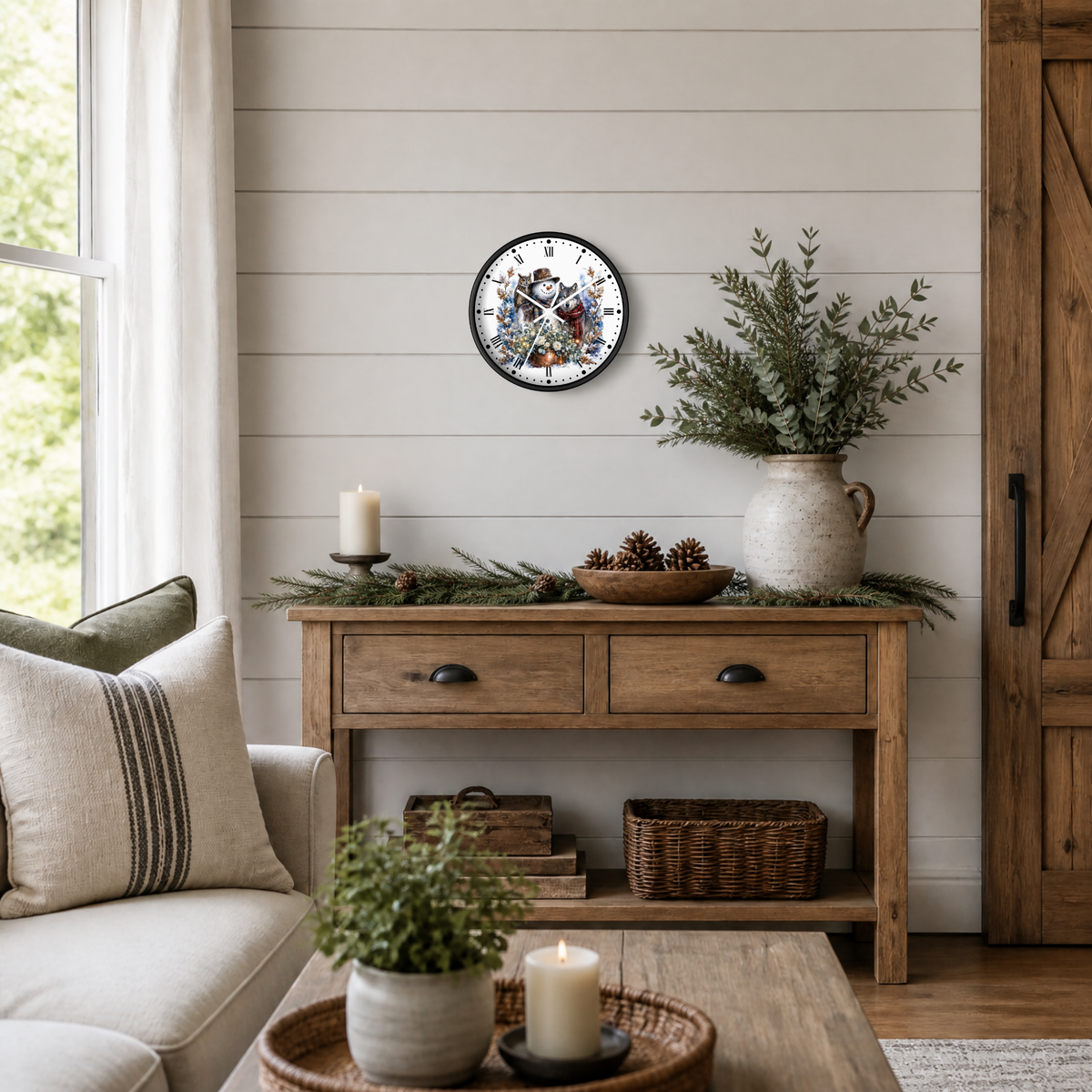 A round wall clock with a festive snowman, wolf, and owl illustration and Roman numerals, styled on a shiplap wall above a rustic wooden console table in a cozy living room setting.