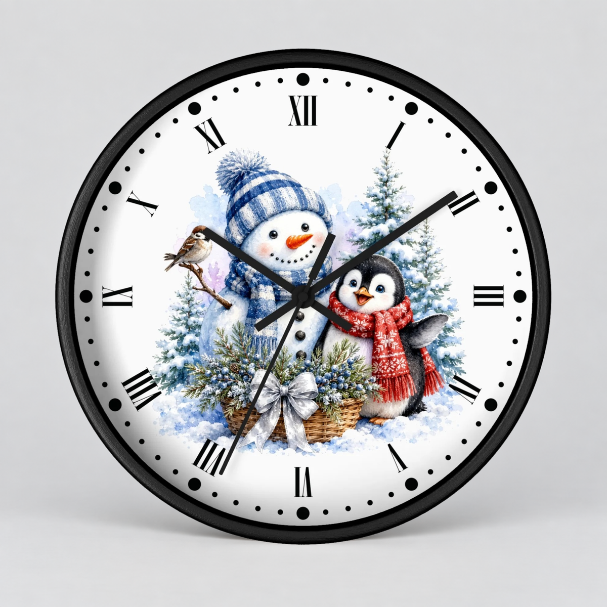 A round wall clock with a black frame and a white face featuring a winter holiday illustration of a snowman and a penguin in a snowy scene with trees and a basket.