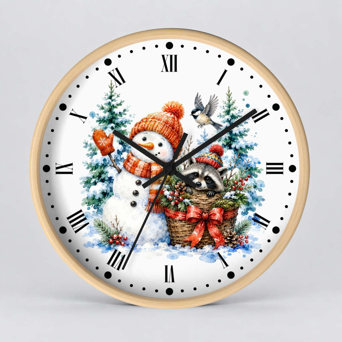 A round wall clock with a light wood frame and a white face, featuring a festive winter illustration of a snowman in an orange hat and scarf, a raccoon in a basket with a red bow, evergreen trees, and a small bird. The clock is shown against a neutral light gray background.