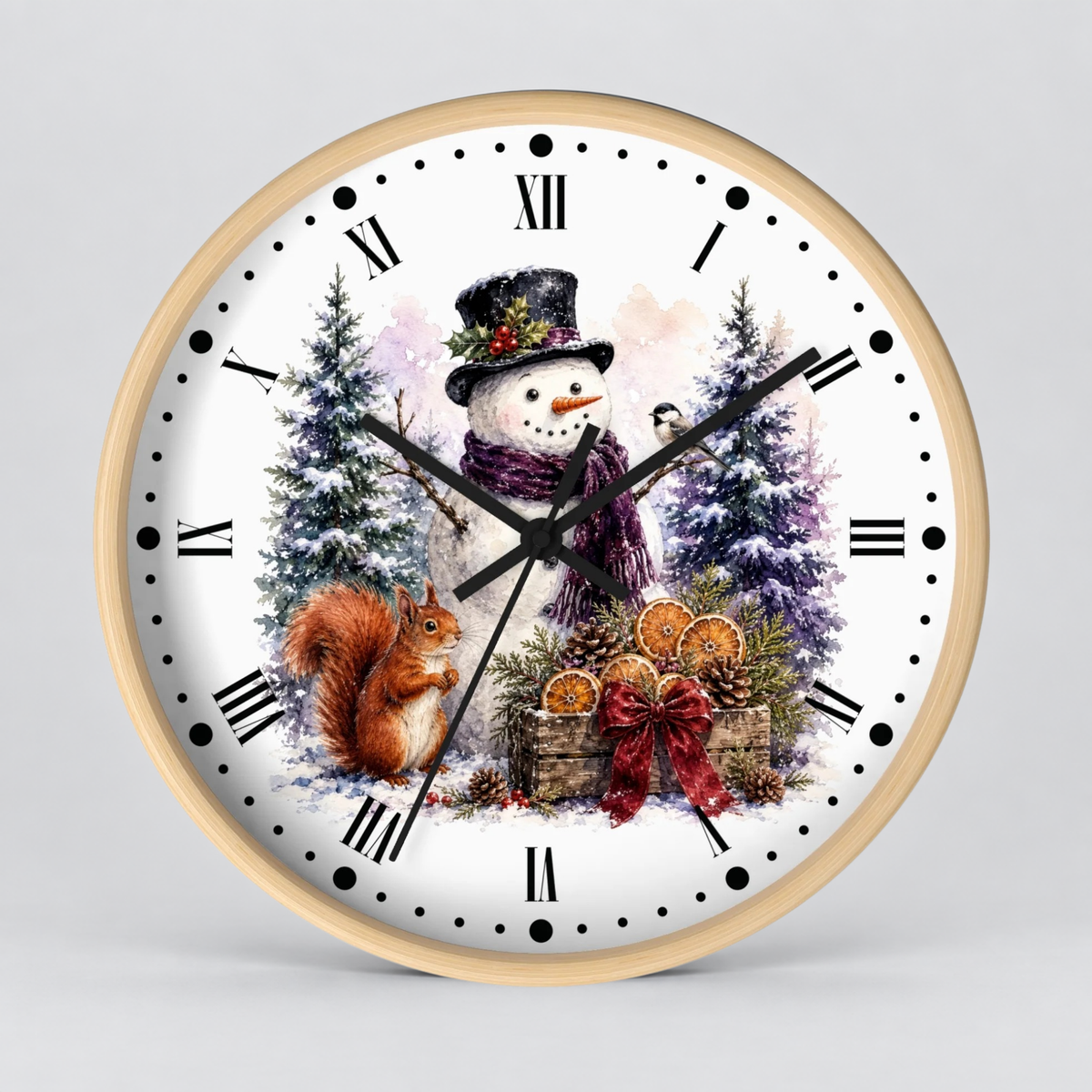 A round wall clock with a light wood frame and a white face featuring a winter holiday illustration of a snowman, a squirrel, evergreen trees, and orange slices, shown on a light gray background.