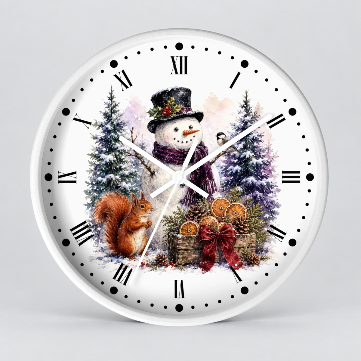 A round white wall clock with a festive winter illustration on the face, featuring a snowman in a top hat, a squirrel, evergreen trees, and a red bow, shown against a light gray background.
