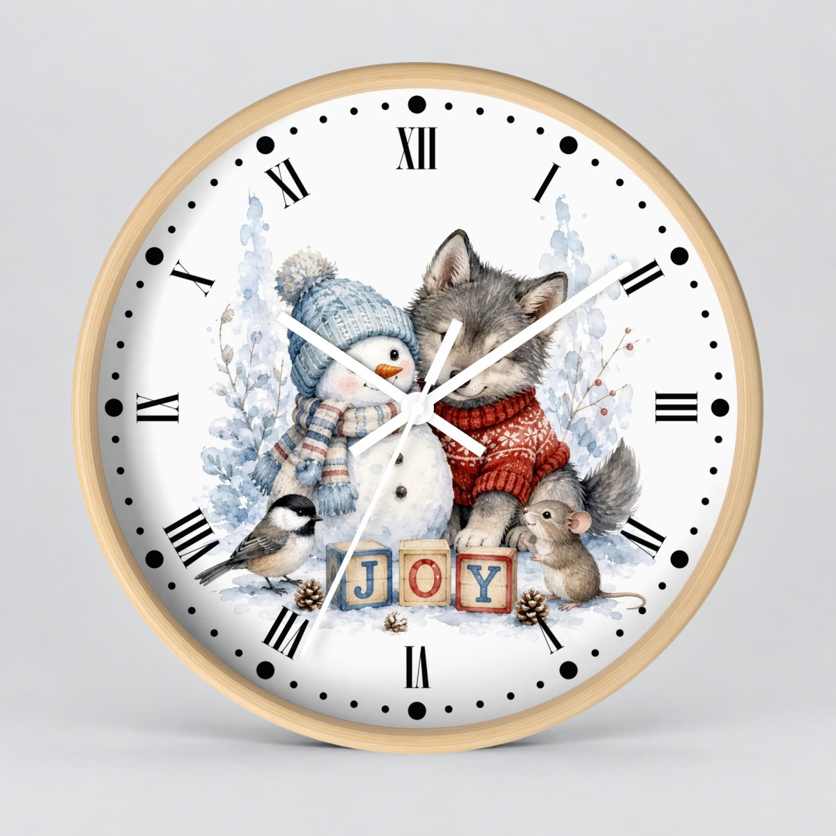 A round wall clock with a light wood frame and a white face featuring a winter illustration of a snowman, wolf, mouse, bird, and the word 'JOY' in wooden blocks.