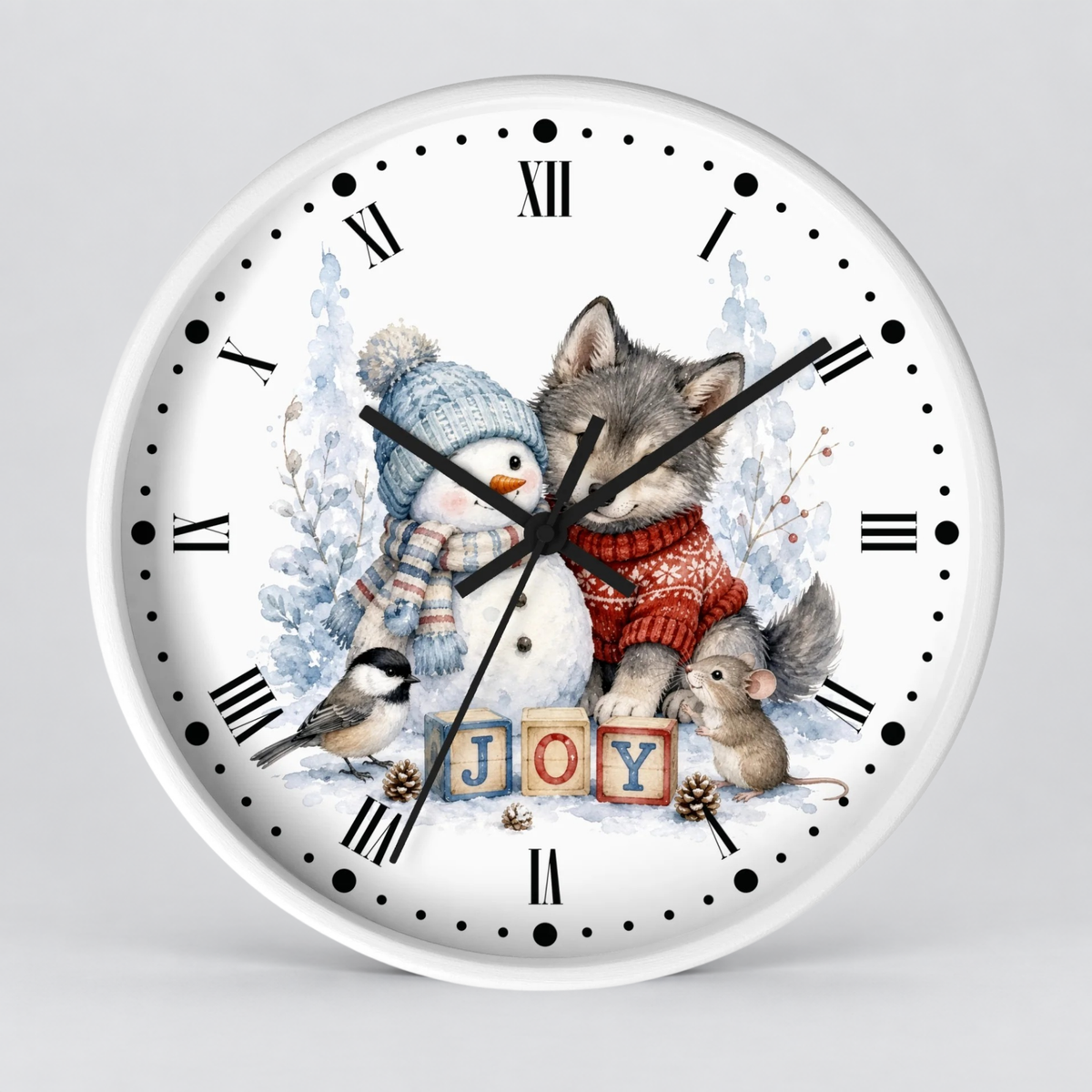 A round white wall clock with black Roman numerals and hands, featuring a festive winter illustration of a wolf, snowman, bird, mouse, and wooden blocks spelling 'JOY'.