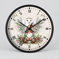 A round wall clock with a black frame and Roman numerals, featuring a festive illustration of a snowy owl with outstretched wings, a red Santa hat, and holiday greenery on a light cream background.