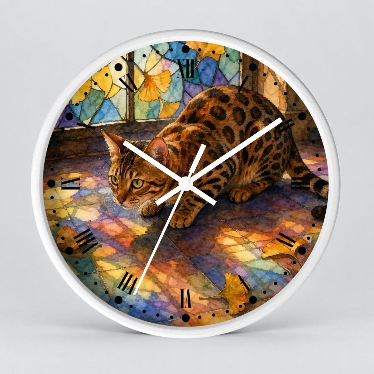 A round wall clock with a white frame and a printed illustration of a spotted cat walking across a colorful stained-glass-like floor. The clock is shown against a light gray studio background.
