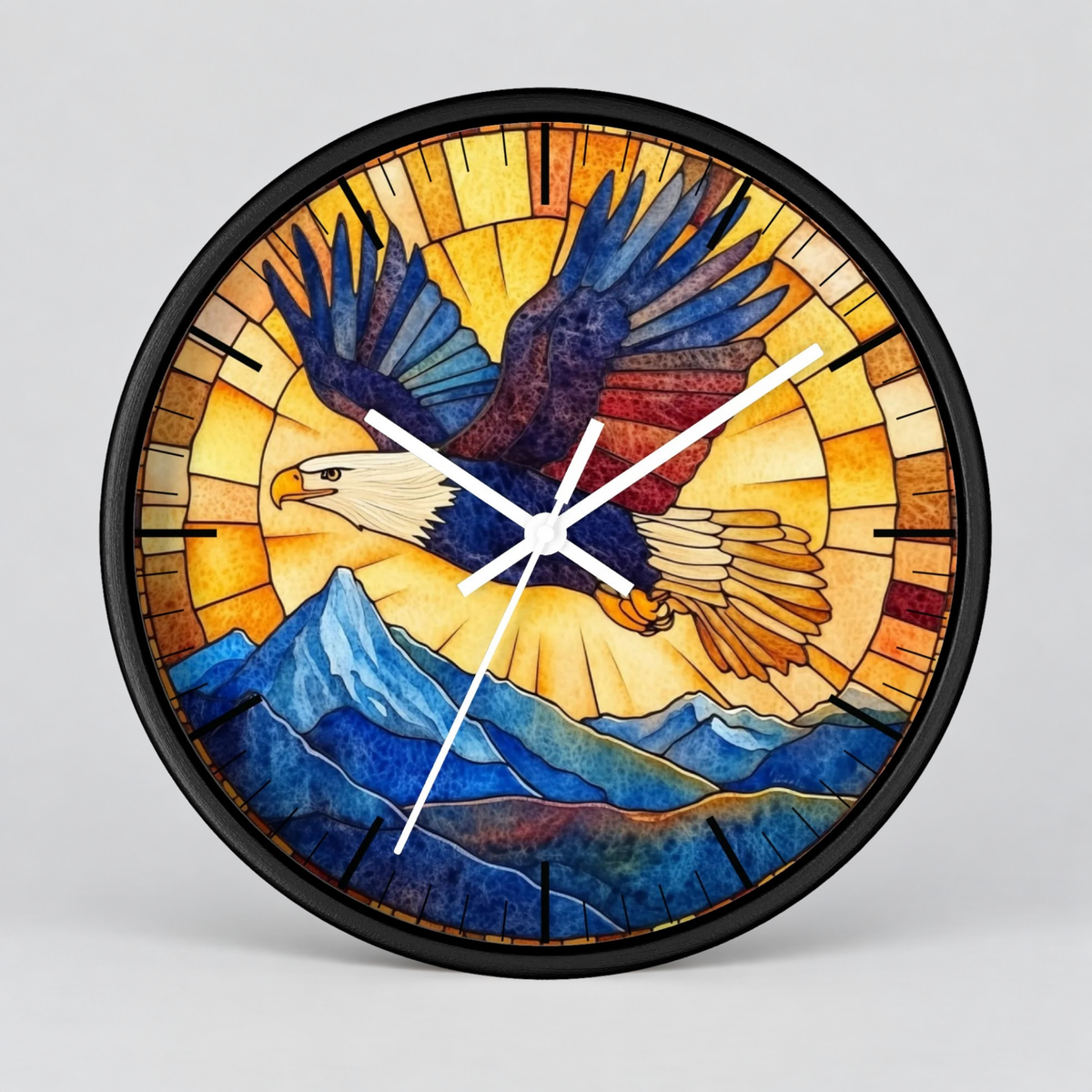 A round wall clock with a black frame and a stained-glass-style design featuring a bald eagle flying over blue mountains against a warm yellow and orange sunburst background.