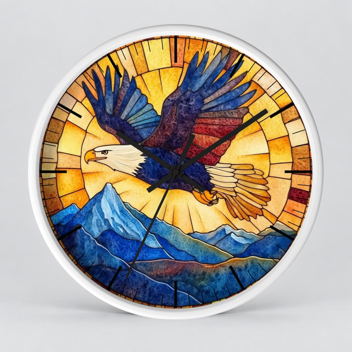 A round wall clock with a white frame and a stained-glass-style illustration of a bald eagle flying over blue mountains, set against a light gray background.