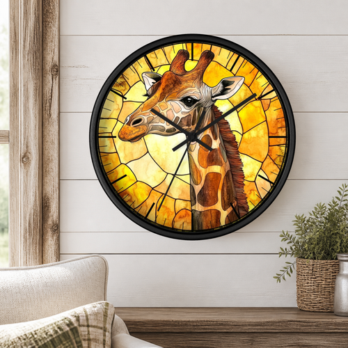 A round wall clock with a giraffe illustration in a stained-glass style, mounted on a white shiplap wall above a wooden table with a potted plant.