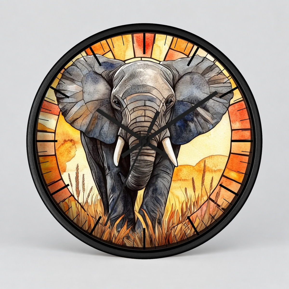Round wall clock with a black frame and a stained-glass-style illustration of an elephant walking through grass, with orange and yellow sunburst tones around the border, shown on a light gray background.