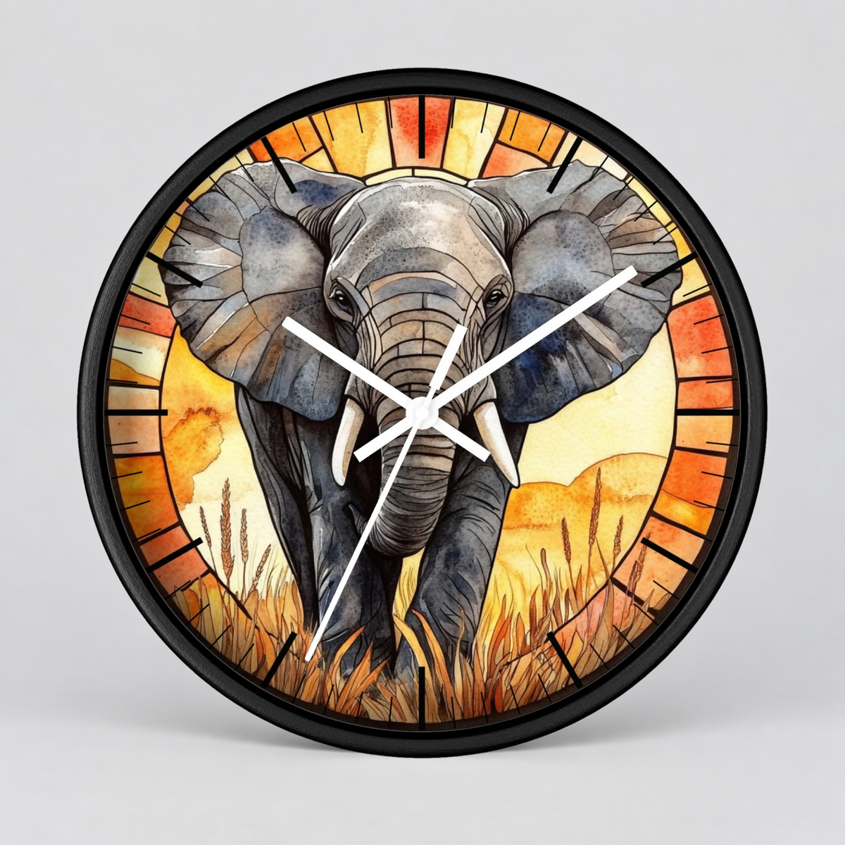 Round wall clock with a black frame and a stained-glass-style illustration of an elephant walking through grass, with orange, yellow, and beige tones and white clock hands, shown on a light gray background.