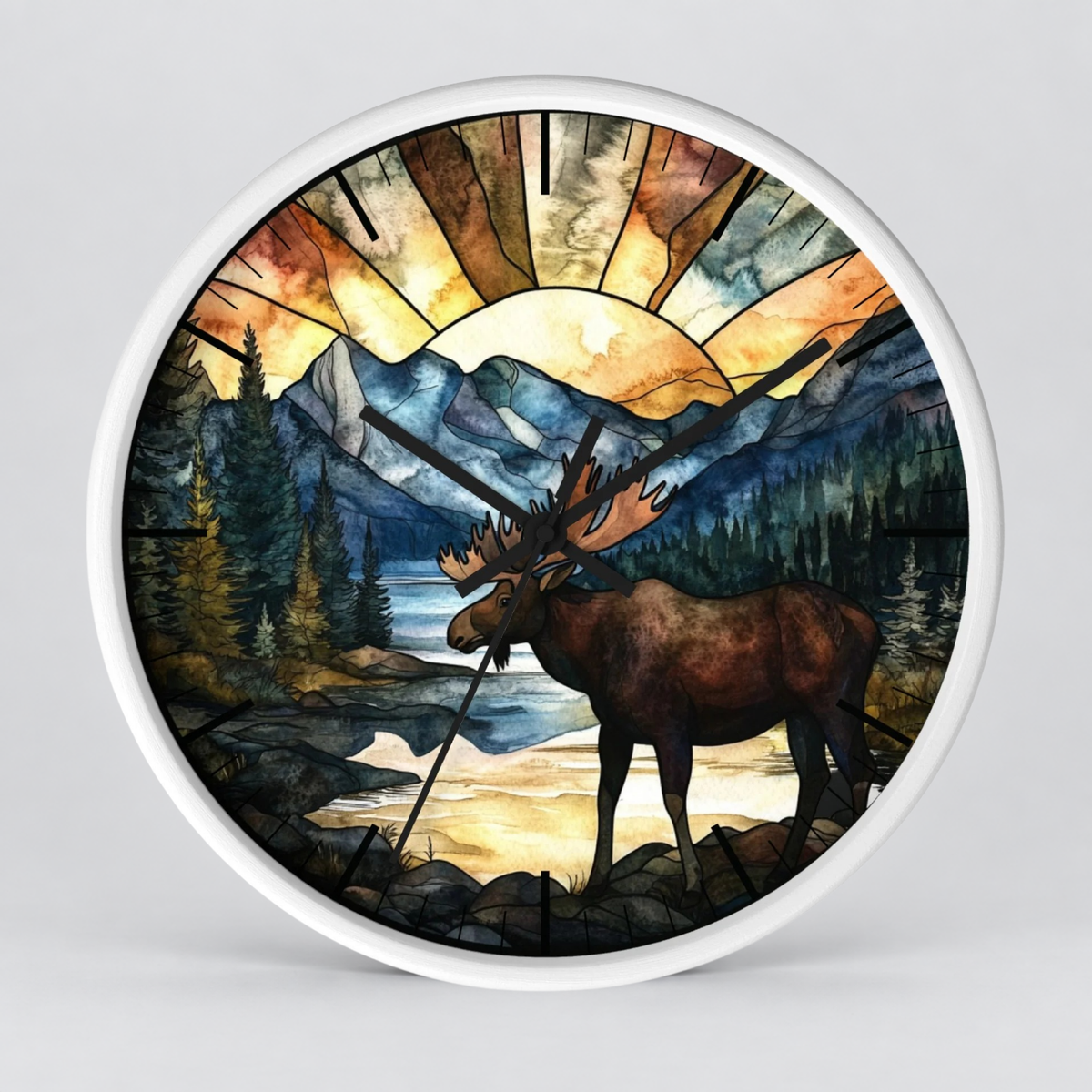 Round wall clock with a white frame and a stained-glass-style nature illustration featuring a moose, mountains, trees, and a glowing sunburst.