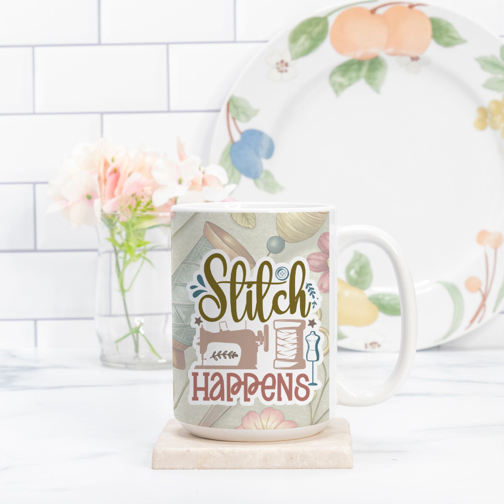 Mug with 'Stitch Happens' design on a marble surface with a floral plate in the background.