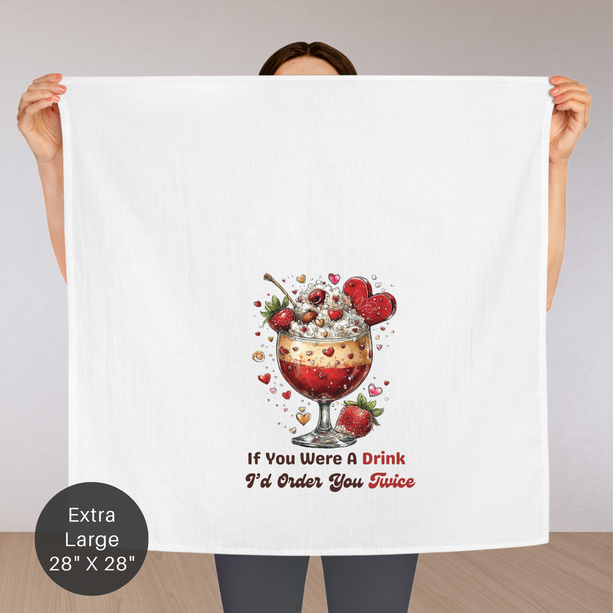 Person holding an extra large tea towel with a drink graphic and text.