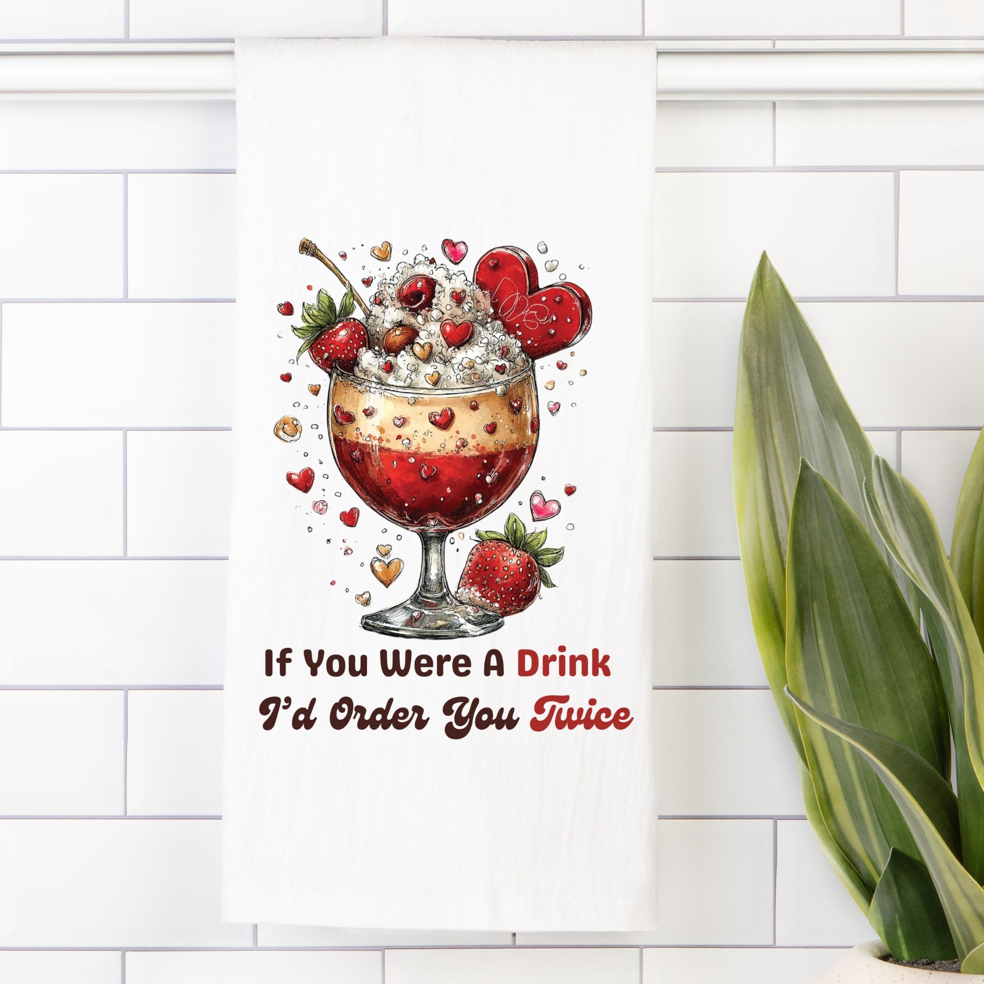 Tea towel with an Illustration of a cocktail with strawberries, hearts, and text ' If You Were A Drink I'd Order You Twice' on a white tiled wall.