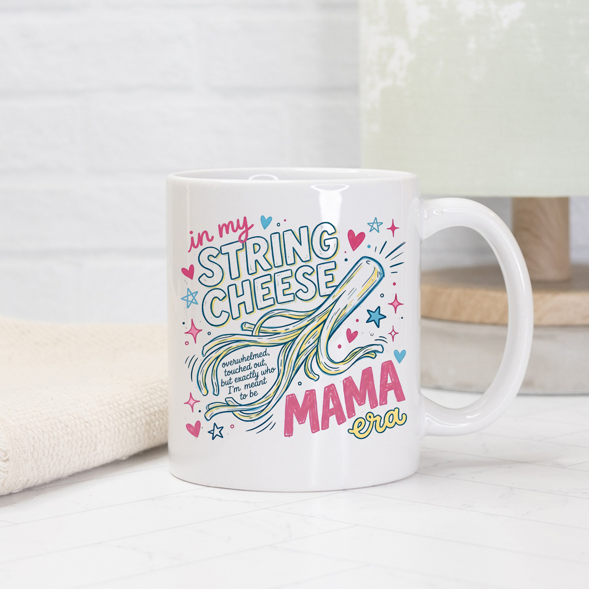 White mug with colorful text 'in my String Cheese Mama era' and design on a white surface