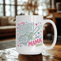White mug with colorful text and design on a wooden table in a home setting
