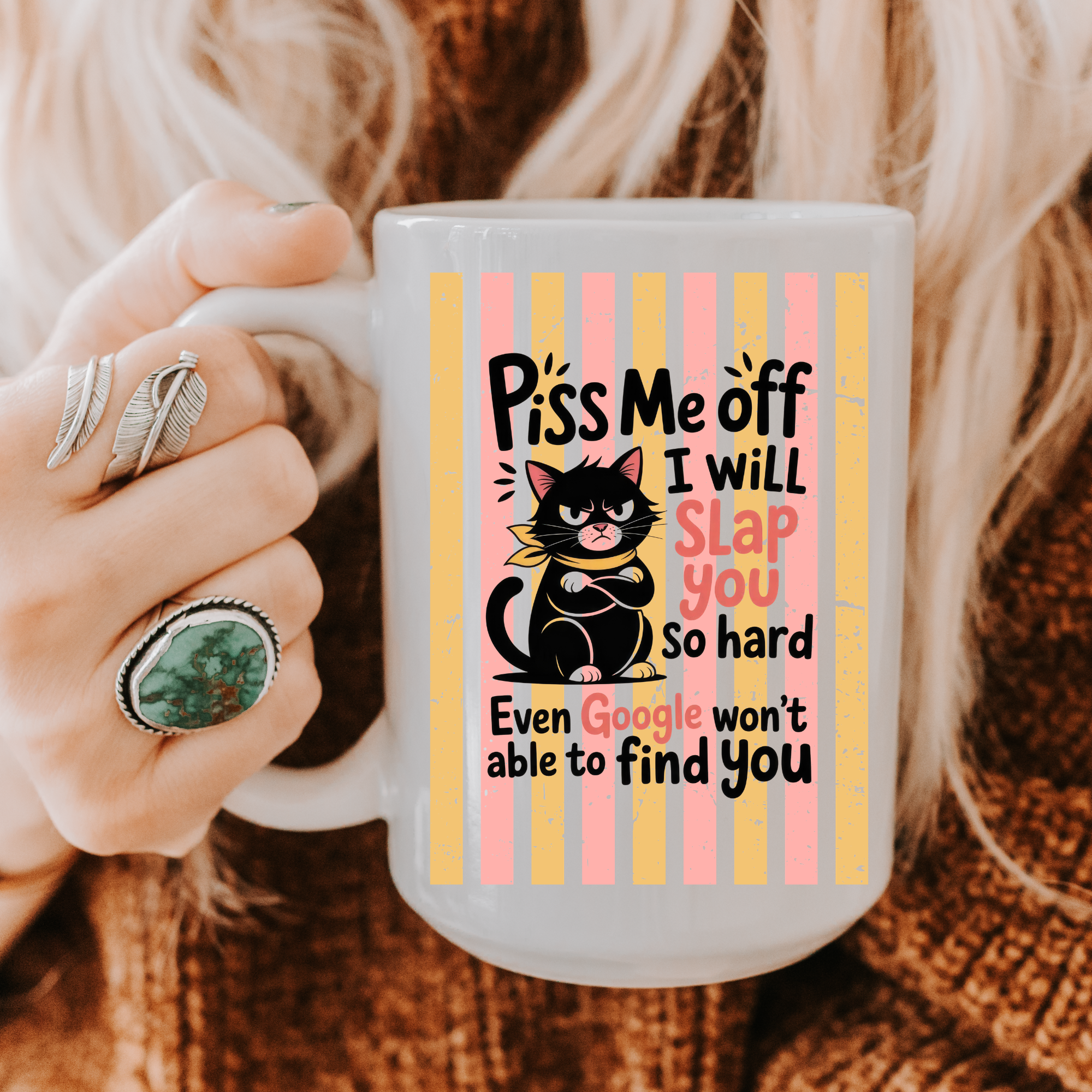 Person holding a 15oz mug with a colorful striped humorous cat design and text.