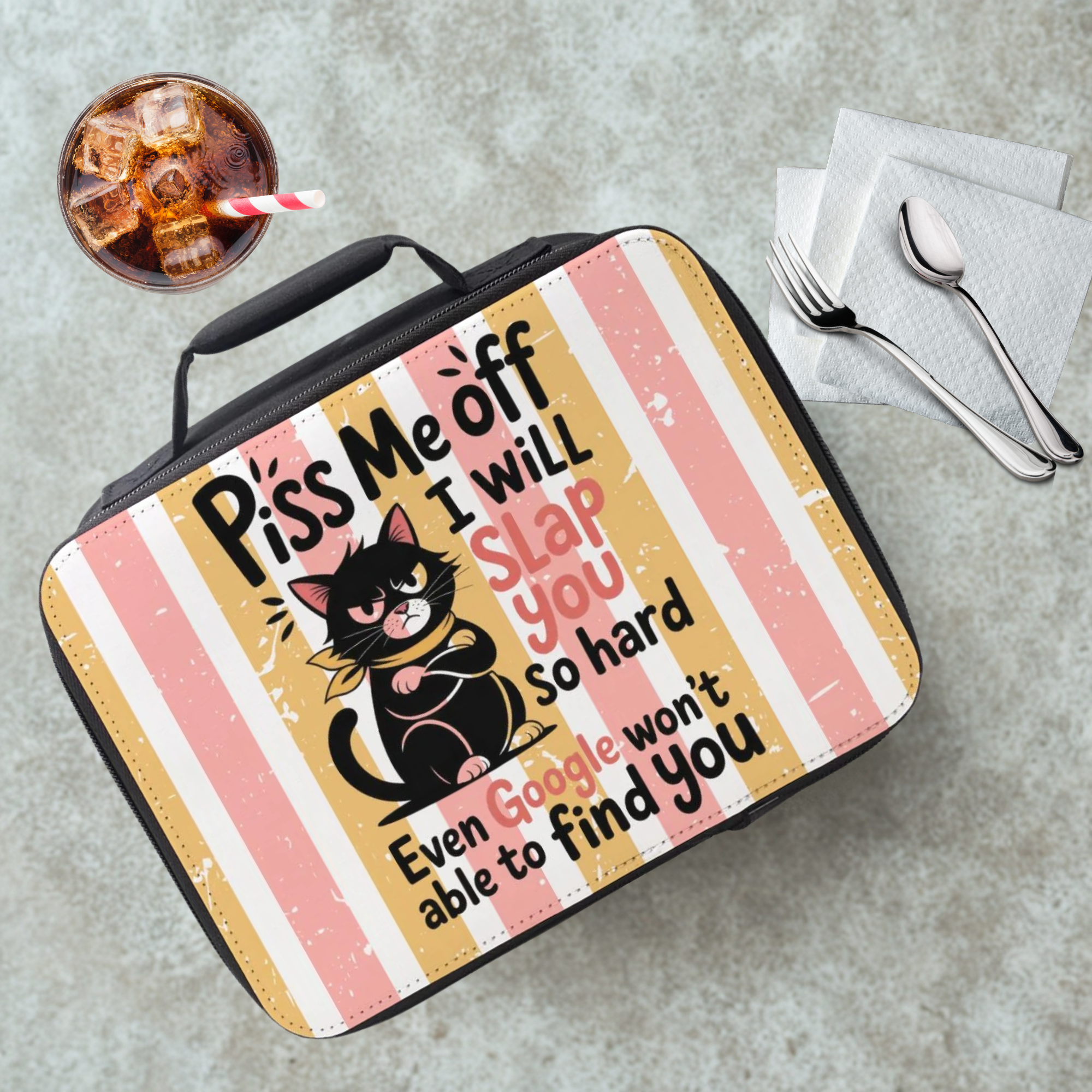 Lunch bag with a cat design and brightly colored stripe background and text on a cafeteria table with a drink and utensils.