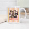 11oz Mug with a black cat illustration and humorous text on a white surface.